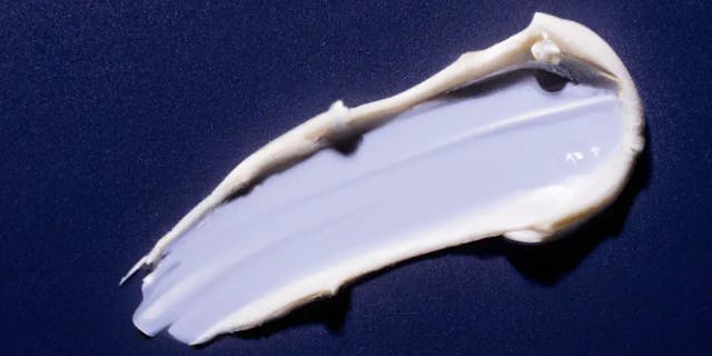 Elegant swatch of white cream on navy blue background