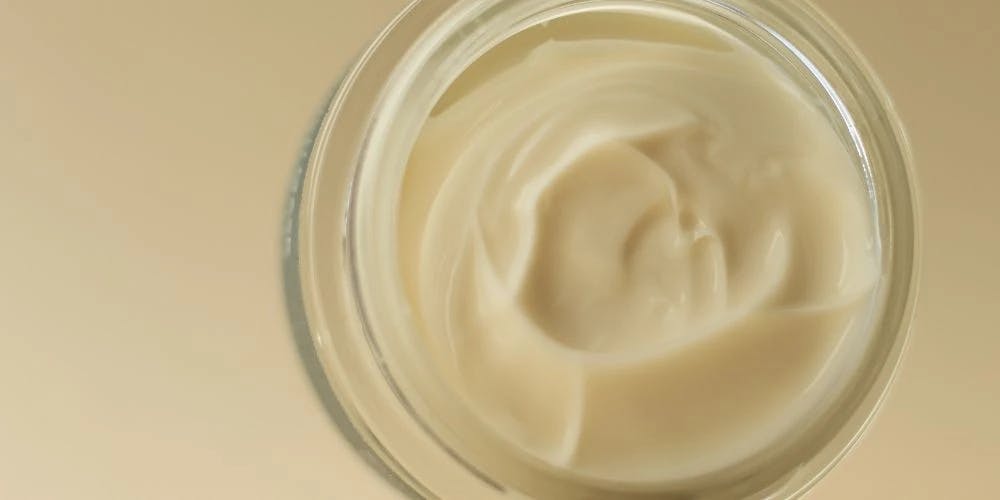 An open jar of Nudmuses Moisturizing Cream