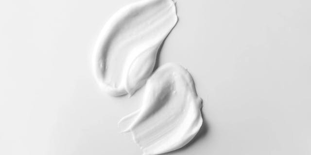 White cream artistically spread on a light gray background