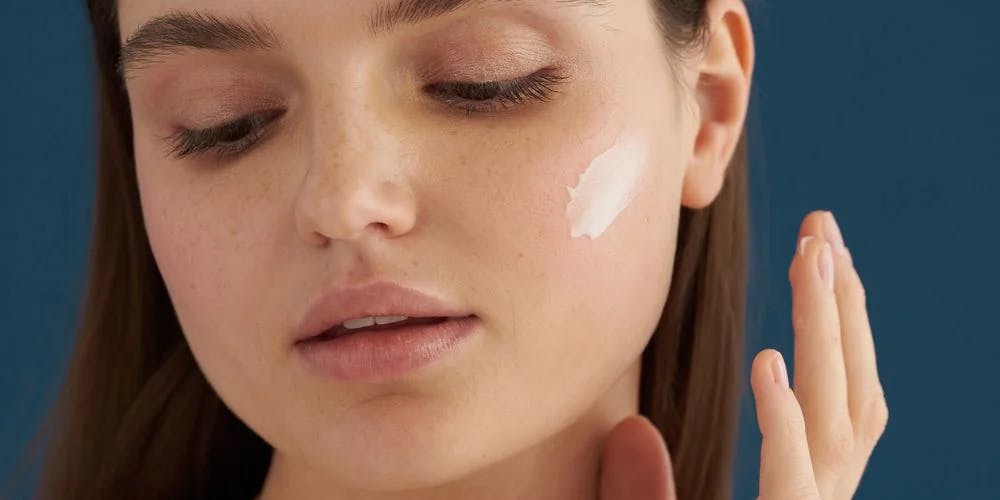 Model applying Nudmuses Hydrating Ritual, Light Moisturizing Cream to the face