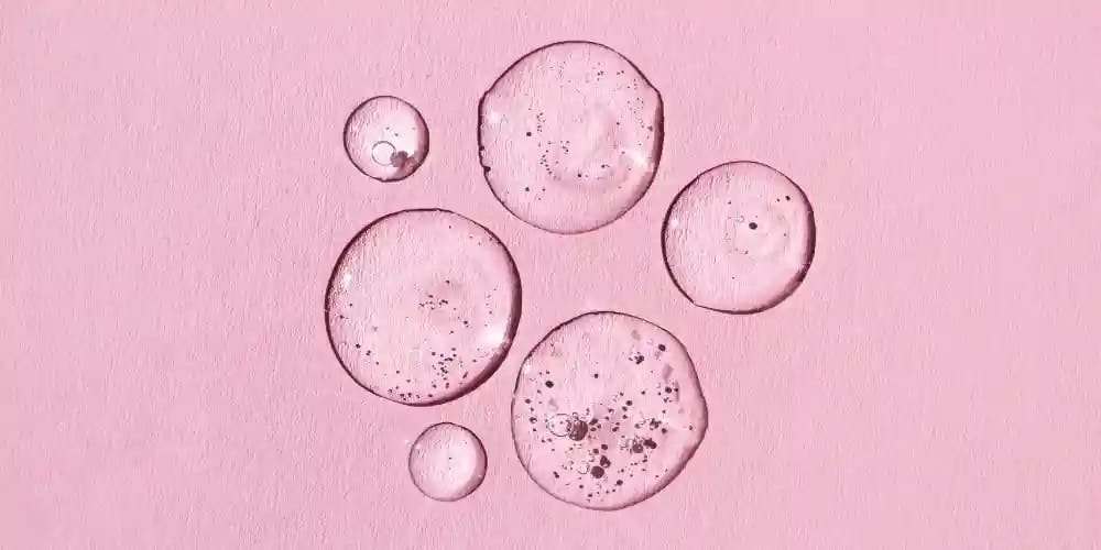 Drops of serum on the pink background